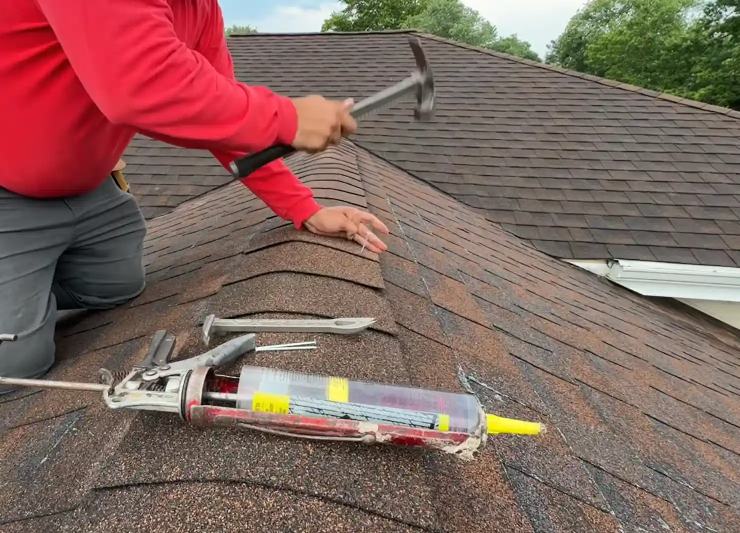 Professional Bismarck Roofing Company repairing an asphalt shingle roof with high-quality sealant.